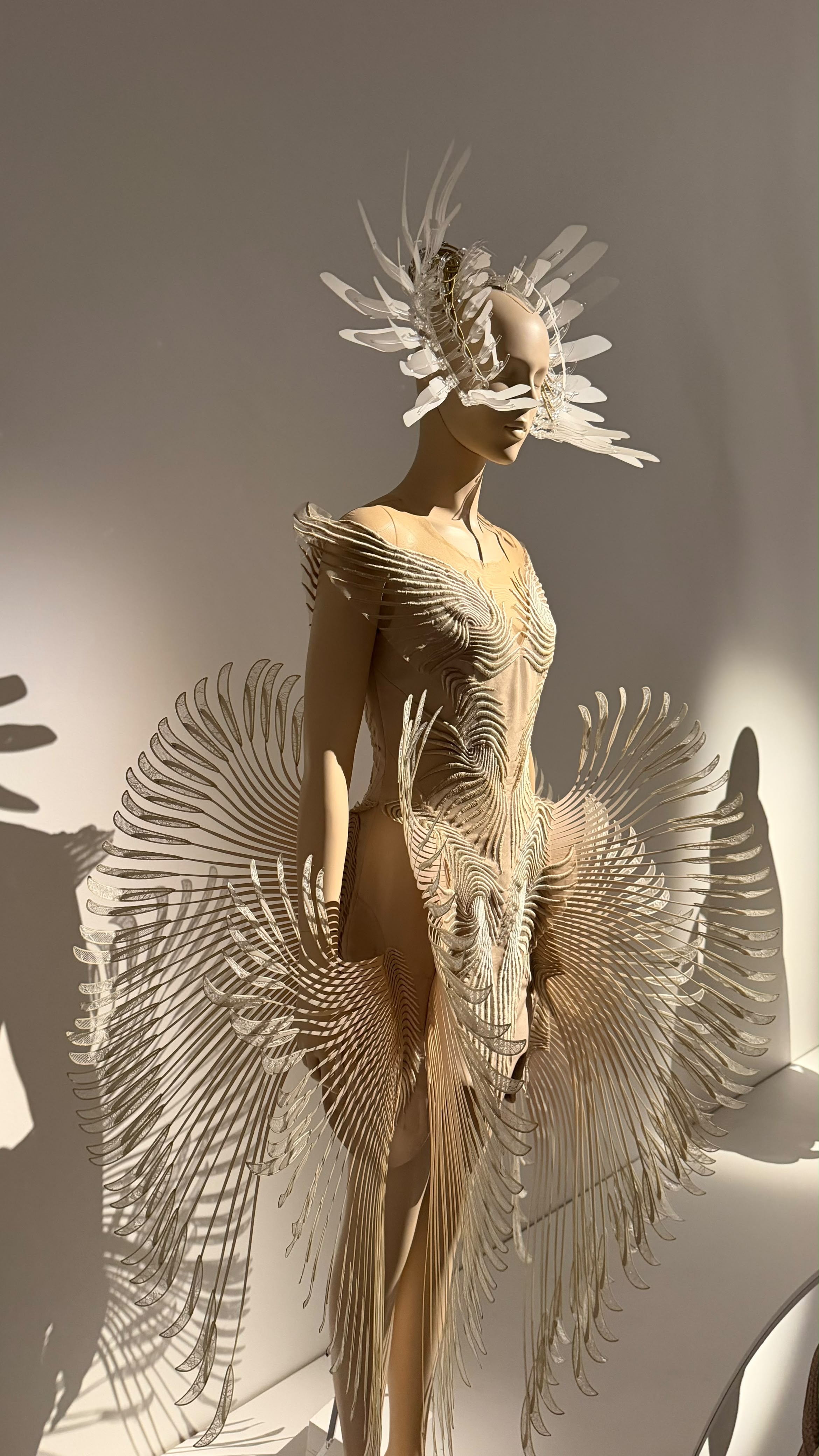 A pale Iris van Herpen dress with radiating sculptural elements and a delicate headpiece