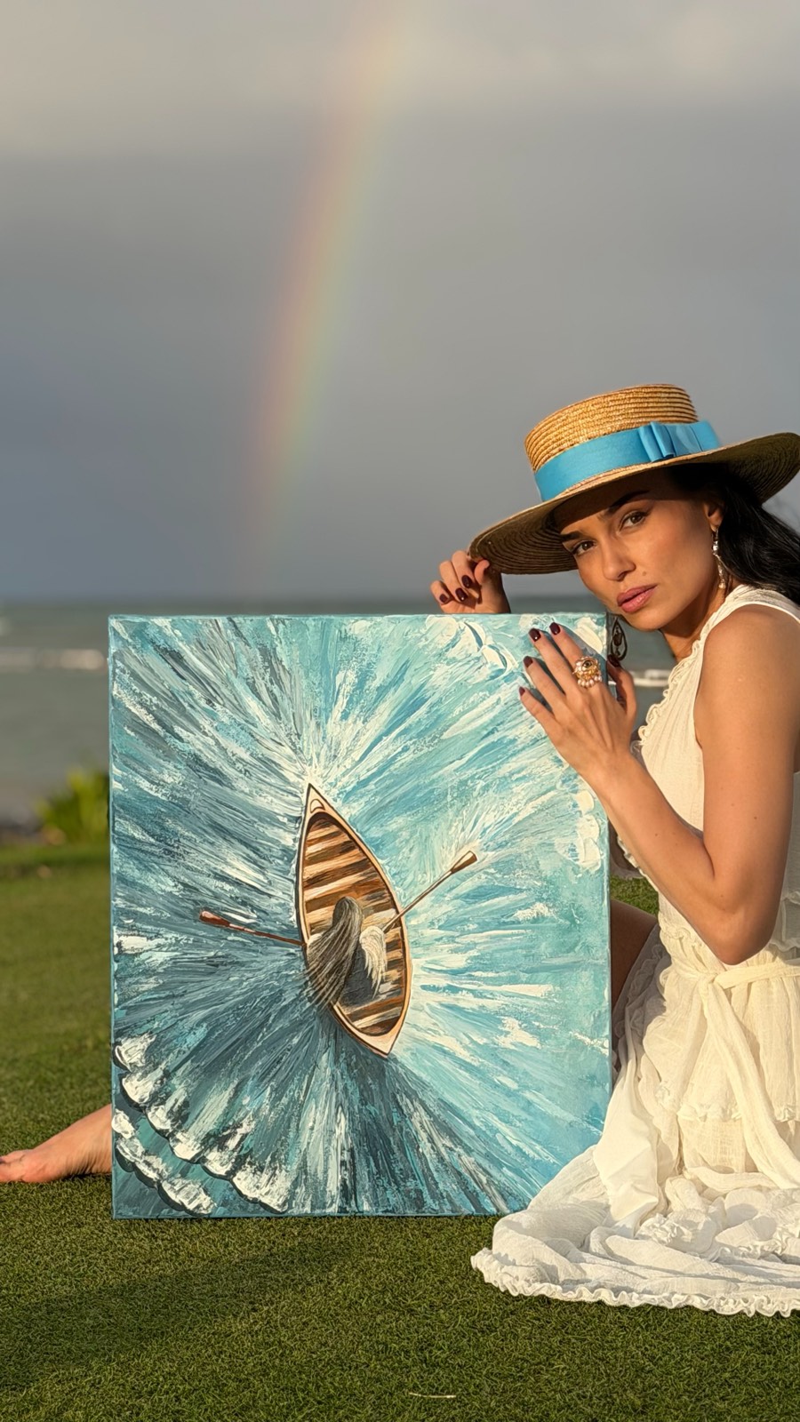 Galina with her painting of a wooden boat on vivid blue water