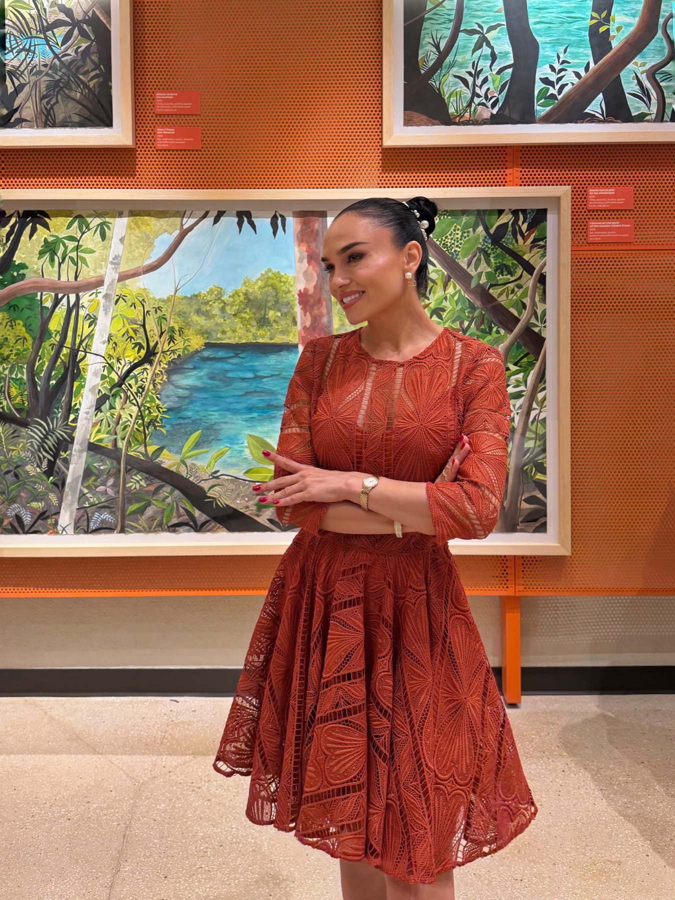 Galina in a rust-coloured dress viewing artworks at Centro Cultural Rainieri in Punta Cana